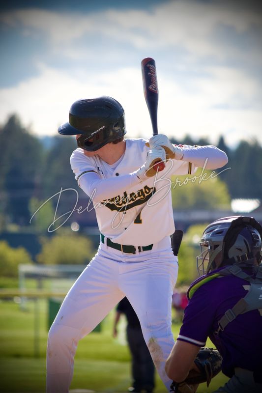 A baseball batter set at the plate, bat cocked back, the catcher crouched at the edge of the frame.